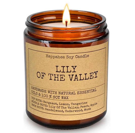 Eco-scented soy candle in amber glass jar with Lily of the Valley scent, creating a warm and inviting ambiance in a cozy home.